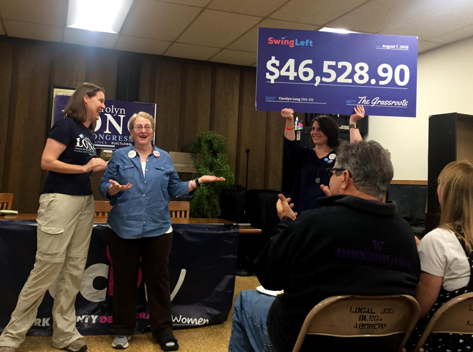 Geni Donaghey — a volunteer with Swing Left, a liberal grassroots group — presents Democrat congressional candidate Carolyn Long with a novelty check for $46,528.90 in Vancouver, Wash., on Saturday. (Photo: David Knowles/Yahoo News)