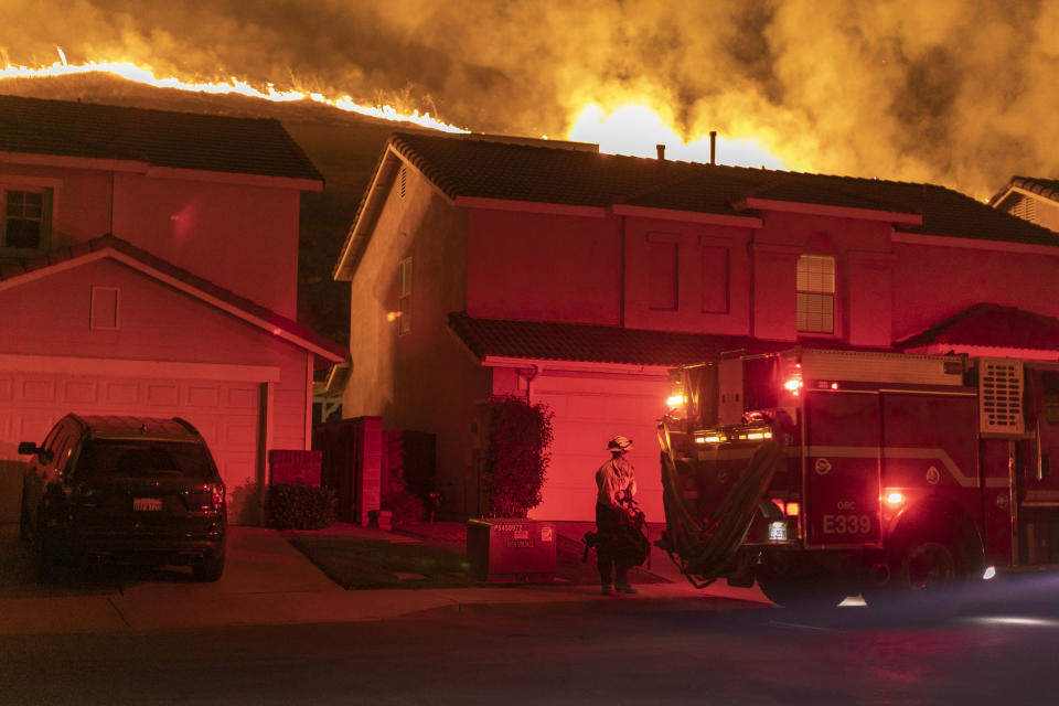 CHINO HILLS, CA - OCTOBER 27: Flames come close to houses during the Blue Ridge Fire on October 27, 2020 in Chino Hills, California. Strong Santa Ana Winds gusting to more than 90 miles per hour have driven the Blue Ridge Fire and Silverado Fire across thousands of acres, grounding firefighting aircraft, forcing tens of thousands of people to flee and gravely injuring two firefighters. More than 8,200 wildfires have burned across a record 4 million-plus acres so far this year, more than double the previous record.  (Photo by David McNew/Getty Images)