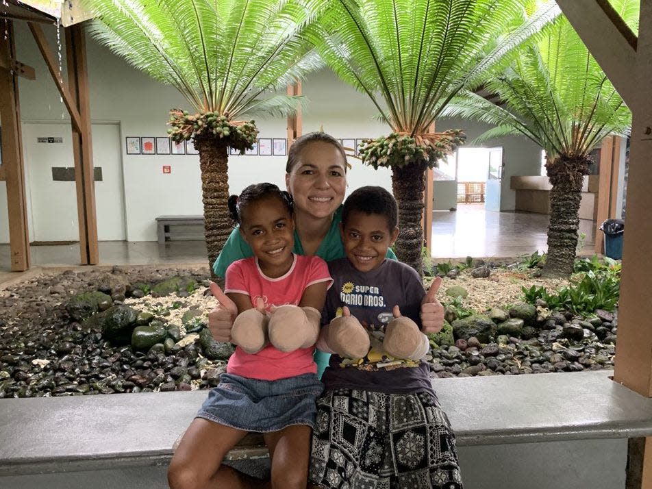 Dr. Julie Woodside with two children who received hand surgeries during a mission trip.