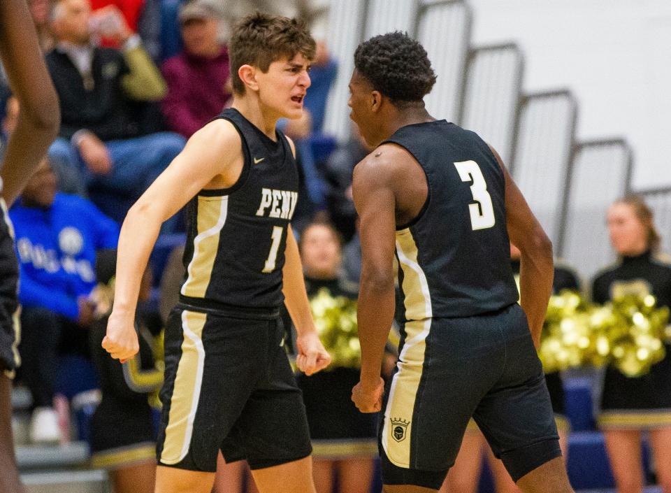 Penn's Joey Garwood (1) and Markus Burton (3) celebrate during the Penn vs. Munster boys regional semifinal basketball game Saturday, March 12, 2022 at Michigan City High School. 