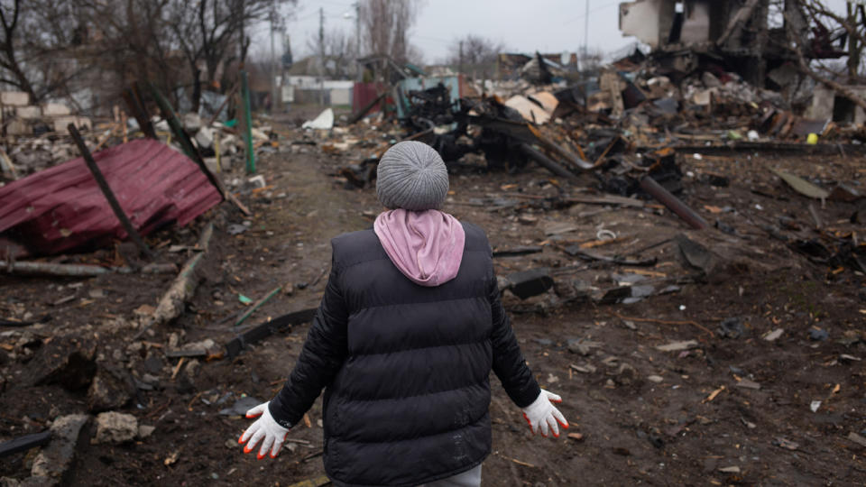 A local resident views rubble and destroyed buildings in her village. 