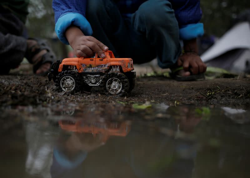 A migrant boy, asylum seeker sent back to Mexico from the U.S. under the Remain in Mexico program officially named Migrant Protection Protocols (MPP), playing with a toy car at provisional campsite near the Rio Bravo in Matamoros