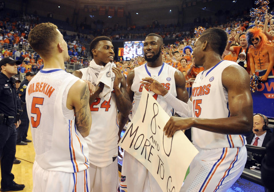 Florida's Florida guard Scottie Wilbekin (5), forward Casey Prather (24), center Patric Young (4) and forward Will Yeguete (15) celebrate afer defeating Kentucky 84-65 in an NCAA college basketball game Saturday, March 8, 2014, in Gainesville, Fla. (AP Photo/Phil Sandlin)