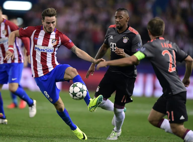 Atletico Madrid's Saul Niguez (L) vies with Bayern Munich's Douglas Costa during the UEFA Champions League Group D match