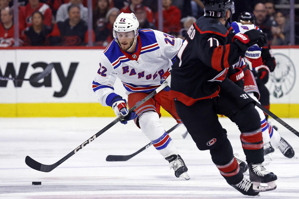 New York Rangers' Jonny Brodzinski (22) moves the puck around Carolina Hurricanes' Tony DeAngelo (77) during the first period in Game 6 of an NHL hockey Stanley Cup second-round playoff series in Raleigh, N.C., Thursday, May 16, 2024. (AP Photo/Karl B DeBlaker)
