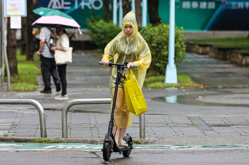 對流雲系旺盛  雙北地區午後降雨（2） 中央氣象署26日表示，午後對流雲系發展旺盛，易有 短延時強降雨，新北市中和區下午下起陣雨，有民眾 穿著雨衣在雨中騎電動滑板車。 中央社記者鄭清元攝  113年6月26日 