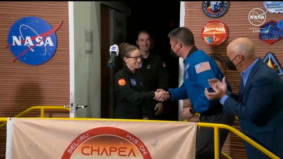 PHOTO: The crew members of the first CHAPEA mission, Kelly Haston shakes hands with NASA Deputy Director Flight Missions Kjell Lindgren, as other crew Ross Brockwell, emerges from their craft, July 6, 2024, at Johnson Space Center in Houston, Texas.  (NASA via AP)