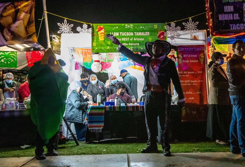 A man calls out to bring in customers to a vendor booth selling tamales during the 30th annual Indio International Tamale Festival at Miles Avenue Park in Indio, Calif., Thursday, Dec. 1, 2022. 