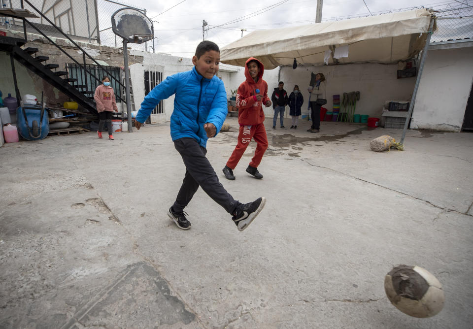 Young Mexican migrants play soccer at a church-run shelter in Ciudad Juarez, Mexico, Sunday, Dec. 18, 2022. Texas border cities were preparing Sunday for a surge of as many as 5,000 new migrants a day across the U.S.-Mexico border as pandemic-era immigration restrictions expire this week, setting in motion plans for providing emergency housing, food and other essentials. (AP Photo/Andres Leighton)