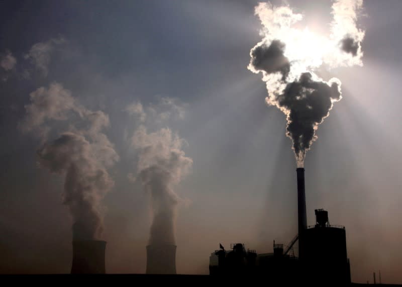 FILE PHOTO: A coal-burning power plant can be seen behind a factory in China's Inner Mongolia Autonomous Region