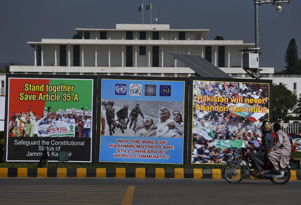 A motorcyclist rides past billboards displaying Indian Kashmiri's struggle for freedom, on a highway near the presidential palace in Islamabad, Pakistan, Saturday, Oct. 27, 2018. The so called Black Day is being observed Oct. 27, throughout Pakistan to express support and solidarity with Kashmiri people in their peaceful struggle for their right to self-determination. (AP Photo/Anjum Naveed)