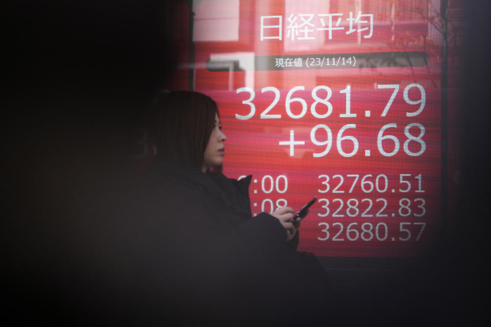 A person walks past an electronic stock board showing Japan's Nikkei 225 index at a securities firm Tuesday, Nov. 14, 2023, in Tokyo. Asian shares were mostly higher Tuesday ahead of potentially market-moving developments, including a U.S.-China summit and data releases from the U.S., Japan and China. (AP Photo/Eugene Hoshiko)