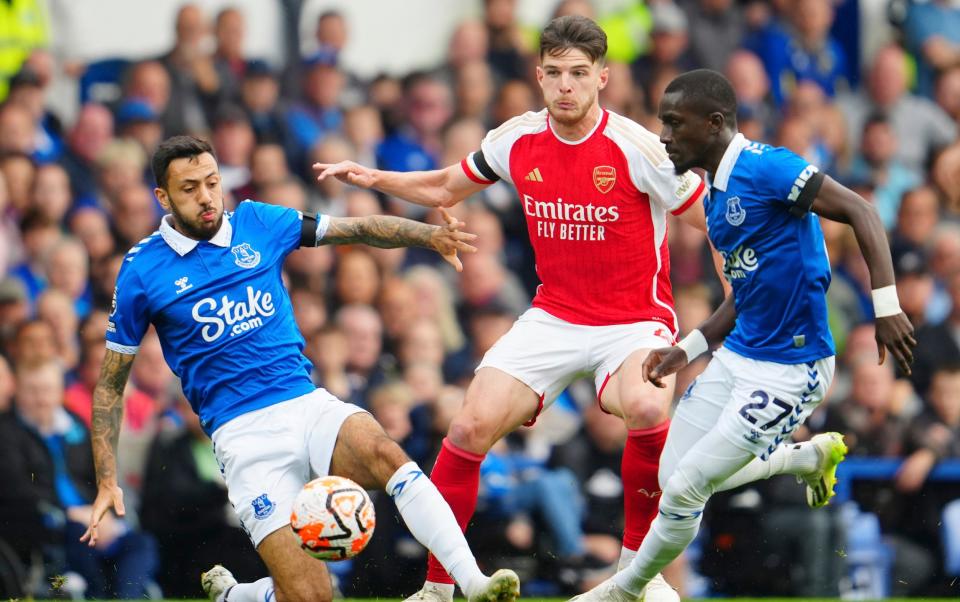 Arsenal's Declan Rice, centre, is challenged by Everton's Dwight McNeil, left