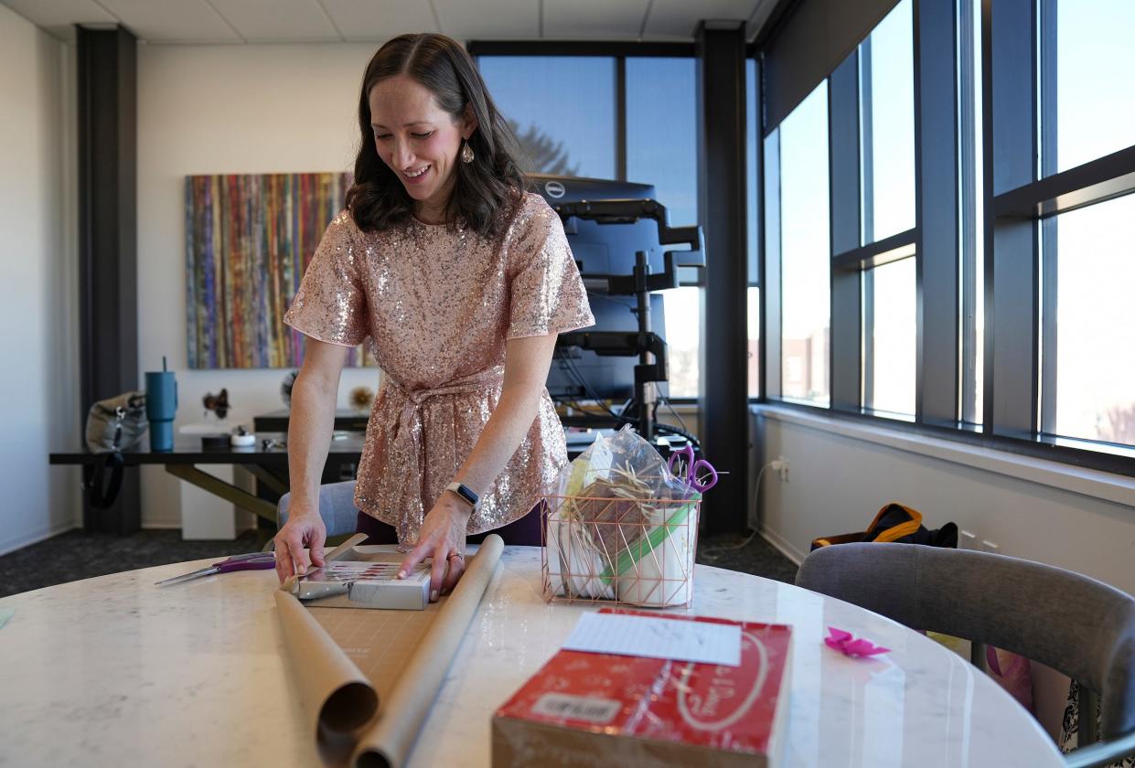 Amber Blakley wraps gifts for clients of Evans May Wealth on Wednesday, Dec. 20, 2023, in Carmel, Ind. Blakley runs her own gift-wrapping business, Westfield Wrapper, and recently competed in QVC's "Ultimate Gift Wrapping Challenge" reality television series.