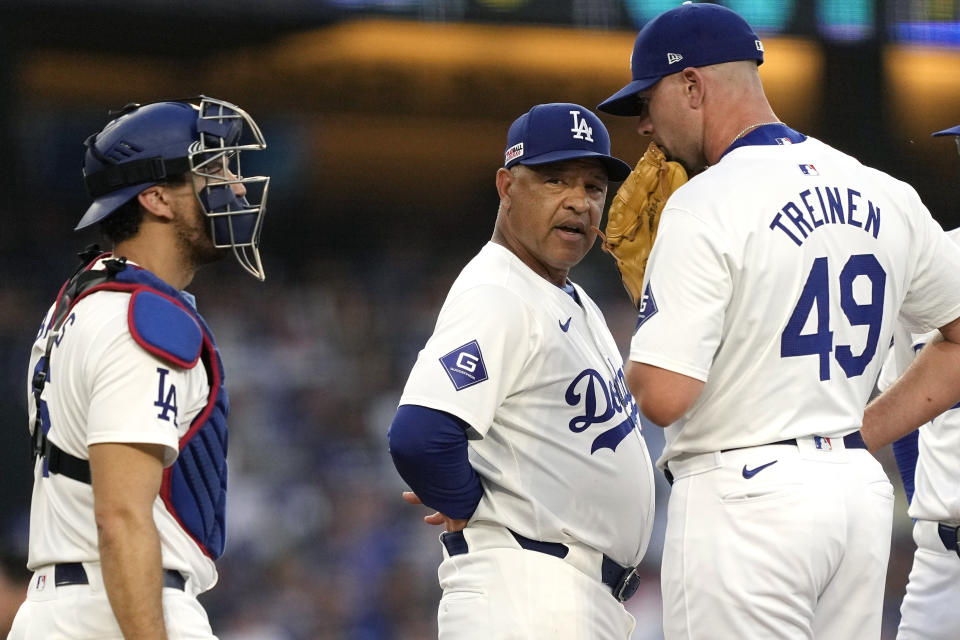 Los Angeles Dodgers manager Dave Roberts, center, talks with relief pitcher Blake Treinen, right, and catcher Austin Barnes during the sixth inning of a baseball game against the Kansas City Royals Saturday, June 15, 2024, in Los Angeles. (AP Photo/Mark J. Terrill)