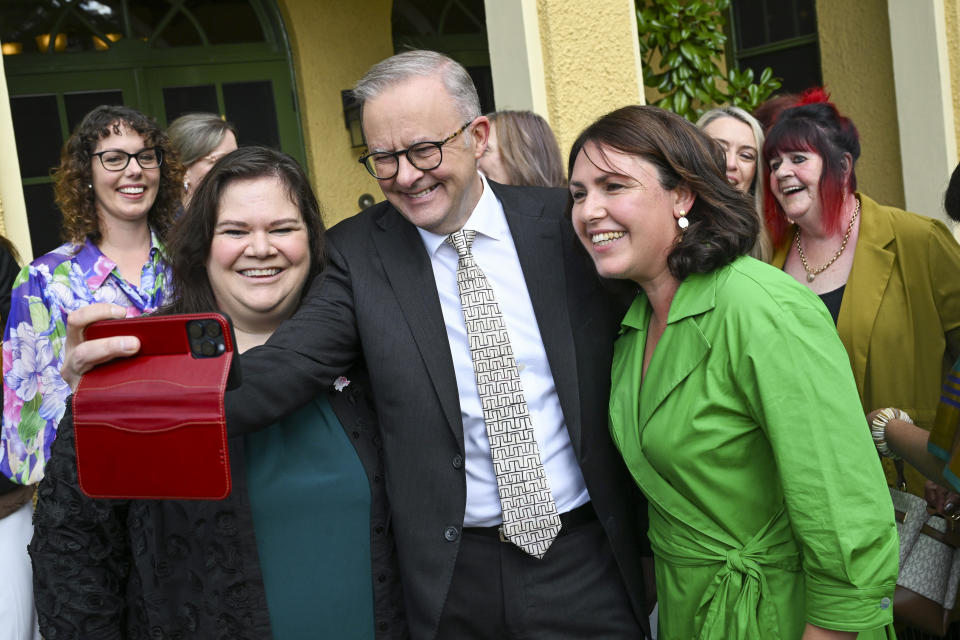 Australian Prime Minister Anthony Albanese, center, takes a selfie with representatives from local women's support organizations during an International Women's Day morning tea at his official residence, the Lodge, in Canberra, Australia, Friday, March 8, 2024. (Lukas Coch/AAP Image via AP)