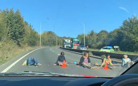 Extinction Rebellion protesters on the A20 near Dover are understood to have glued their hands to the road to block traffic - Credit: Jade Evans/PA