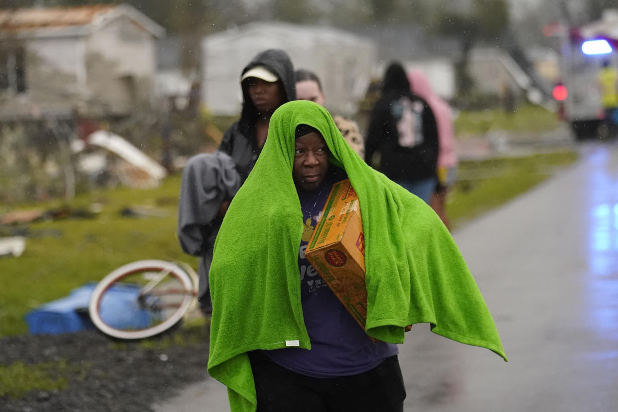 Allyson Mitchell walks in the rain after she arrived to help her niece whose home was destroyed from a tornado that tore through the area in Killona, La., about 30 miles west of New Orleans in St. James Parish, Wednesday, Dec. 14, 2022. (AP Photo/Gerald Herbert)