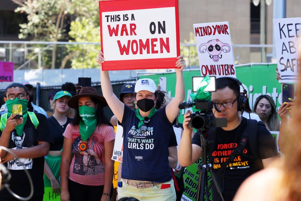 Protesters hold handmade signs.