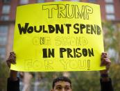 <p>A demonstrator holds a placard as others wait to enter the Albert V. Bryan US Courthouse in Alexandria, Virginia on July 31, 20187, for the opening of the jury selection for the Paul Manafort trial. (Photo: Jim Watson/AFP/Getty Images) </p>