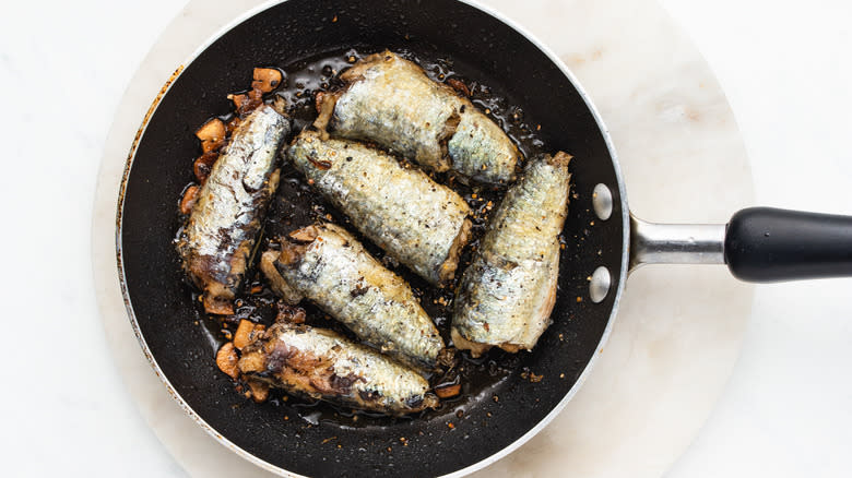 Sardines frying in pan