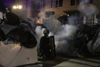 Tear gas fills the air during protests, Friday, Sept. 18, 2020, in Portland, Ore. The protests, which began over the killing of George Floyd, often result frequent clashes between protesters and law enforcement. (AP Photo/Paula Bronstein)