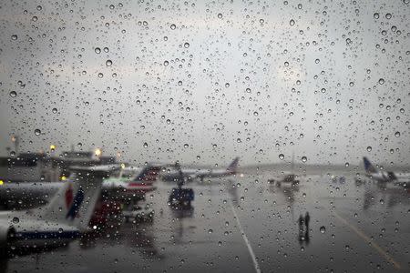 The tarmac of LaGuardia airport is pictured through a window on the day before Thanksgiving, in New York November 26, 2014. REUTERS/Carlo Allegri