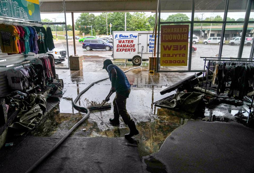 Oscar Perez moves water to entrance of Citi Trends at Branch Plaza.