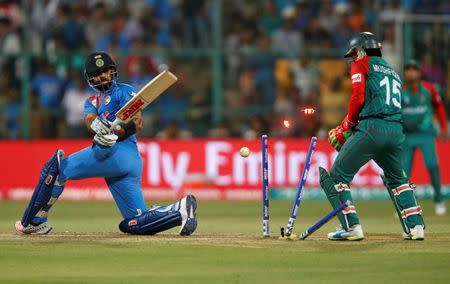 Cricket - India v Bangladesh - World Twenty20 cricket tournament - Bengaluru, India, 23/03/2016. India's Virat Kohli (L) is bowled as Bangladesh's wicketkeeper Mushfiqur Rahim looks on. REUTERS/Danish Siddiqui