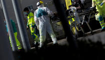 Medical personnel in protective gear move a patient at a hospital in Antwerp, Belgium, Monday, April 13, 2020. The new coronavirus causes mild or moderate symptoms for most people, but for some, especially older adults and people with existing health problems, it can cause more severe illness or death. (AP Photo/Virginia Mayo)