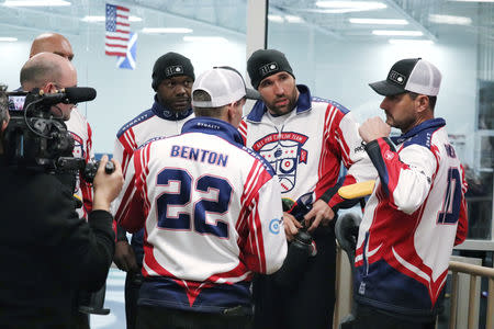 (L-R) Teammates Keith Bulluck and Jared Allen listen as Marc Bulger speaks and coach John Benton looks on at the USA Curling Men's Challenge Round in Blaine, Minnesota, U.S. January 3, 2019. All Pro Curling/Handout via REUTERS