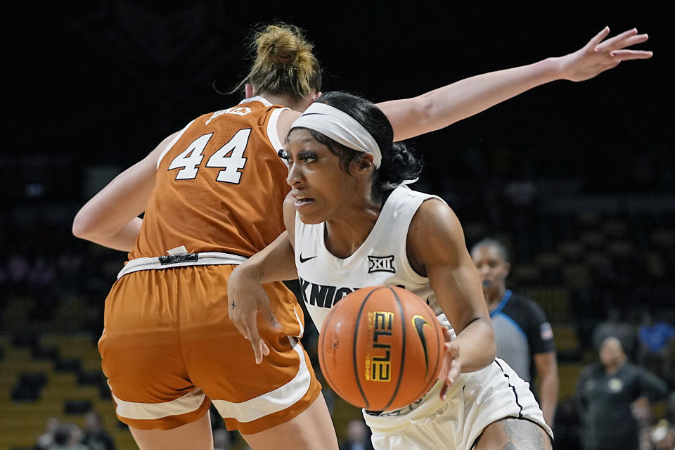 Central Florida guard Kaitlin Peterson, right, drives past Texas forward Taylor Jones (44) during the first half of an NCAA college basketball game, Saturday, Feb. 24, 2024, in Orlando, Fla. (AP Photo/John Raoux)