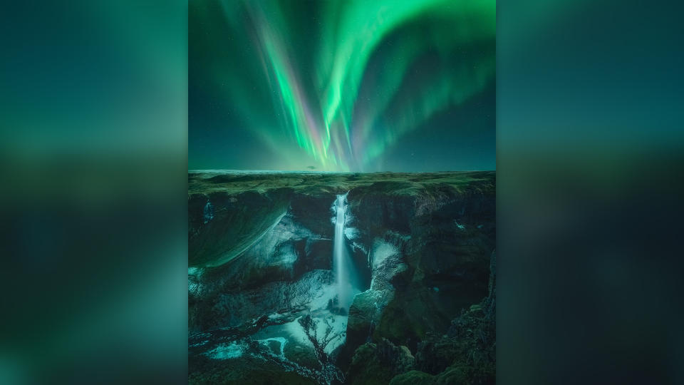 Green northern lights over Haifoss, Iceland.