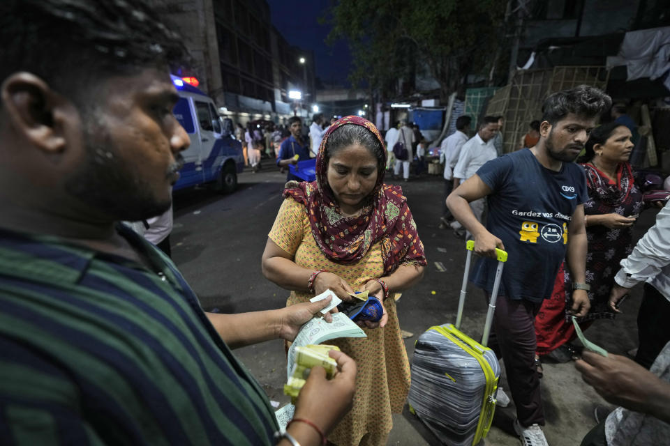 An asthma patient purchases a token for collecting fish from a counter as she arrives for a fish therapy, in Hyderabad, India, Saturday, June 8, 2024. Every year thousands of asthma patients arrive here to receive this fish therapy from the Bathini Goud family, a secret formula of herbs, handed down by generations only to family members. The herbs are inserted in the mouth of a live sardine, or murrel fish, and slipped into the patient's throat. (AP Photo/Mahesh Kumar A.)