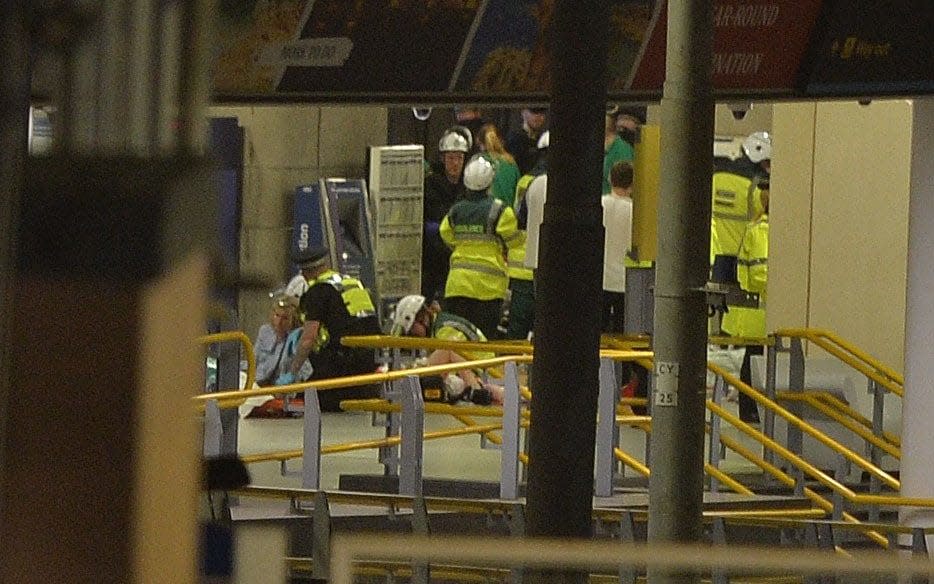 Bomb police tend to an injured woman at the scene of the attack - Zenpix Ltd