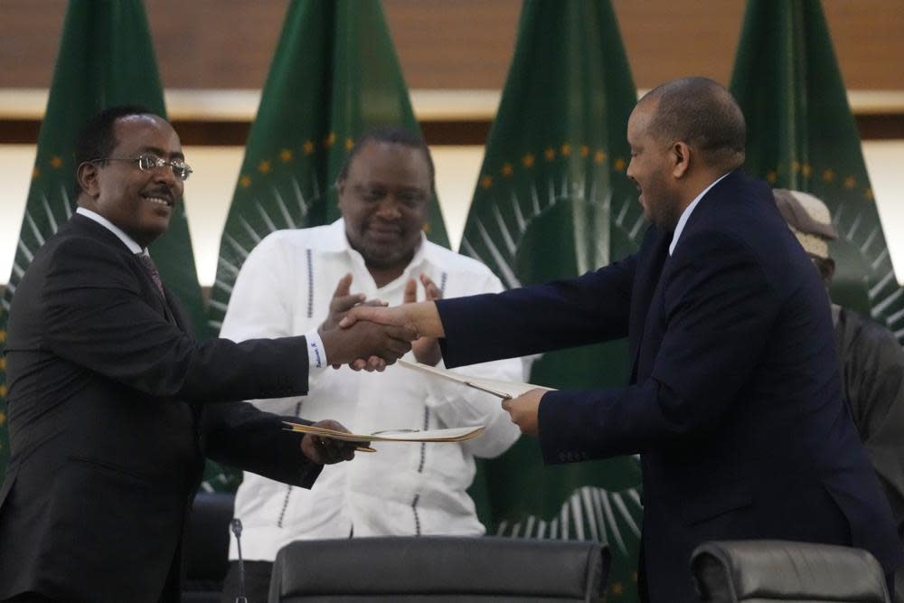 Lead negotiator for Ethiopia’s government, Redwan Hussein, left, shakes hands with lead Tigray negotiator Getachew Reda, as Kenya’s former president, Uhuru Kenyatta looks on, after the peace talks in Pretoria, South Africa, Wednesday, Nov. 2, 2022. (AP Photo/Themba Hadebe)