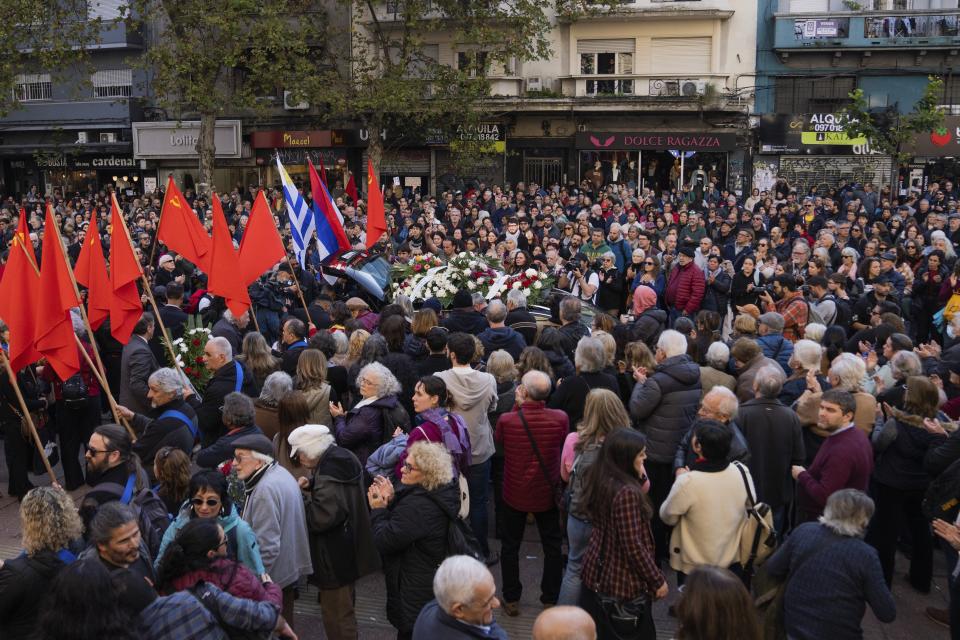People hold a tribute for Amelia Sanjurjo during her funeral service held at the University of the Republic in Montevideo, Uruguay, Thursday, June 6, 2024. The Uruguayan Prosecutor’s Office confirmed that the human remains found in June 2023 at the 14th Battalion of the Uruguayan Army belong to Sanjurjo, a victim of the 1973-1985 dictatorship who was 41 years old and pregnant at the time of her disappearance. (AP Photo/Matilde Campodonico)