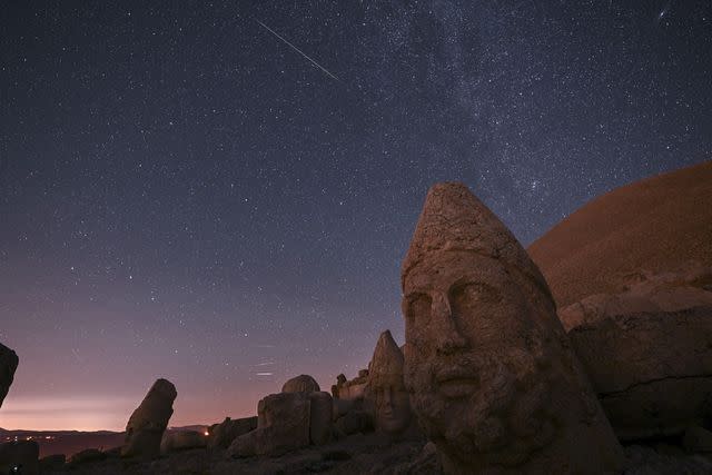 <p>Murat Sengul/Anadolu via Getty</p> Views of the Perseid meteor shower at Mount Nemrut Ruins in Adiyaman, Turkey.