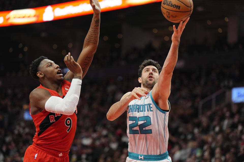 Charlotte Hornets' Vasilije Micić (22) moves toward the basket as Toronto Raptors guard RJ Barrett (9) defends during first-half NBA basketball game action in Toronto, Sunday, March 3, 2024. (Frank Gunn/The Canadian Press via AP)