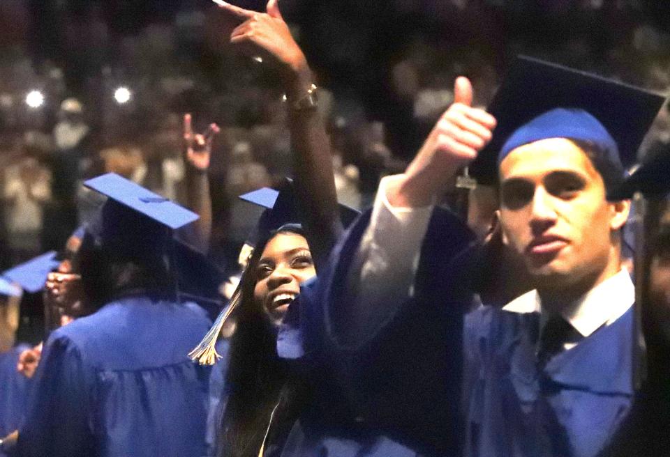 Mainland High School seniors wave to family and friends in the crowd, Tuesday, May 24, 2022, after entering the Ocean Center for their commencement exercise.