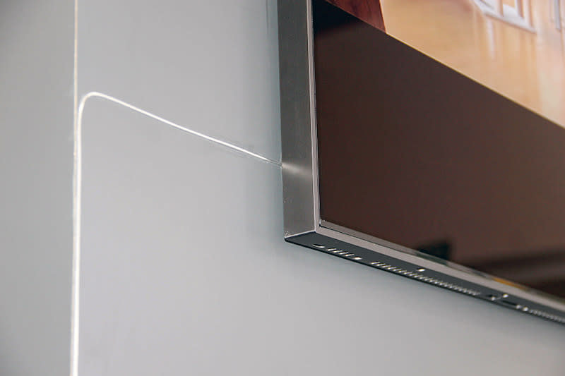 It's so thin that it isn't much of an eyesore if you were to tape it to the wall. The cable is in-wall rated, by the way.