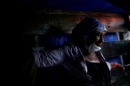 Eufemia Garcia, 48, who lost 50 members of her family during the eruption of the Fuego volcano, observes soldiers finding human remains at her house in San Miguel Los Lotes in Escuintla, Guatemala, June 12, 2018. REUTERS/Carlos Jasso