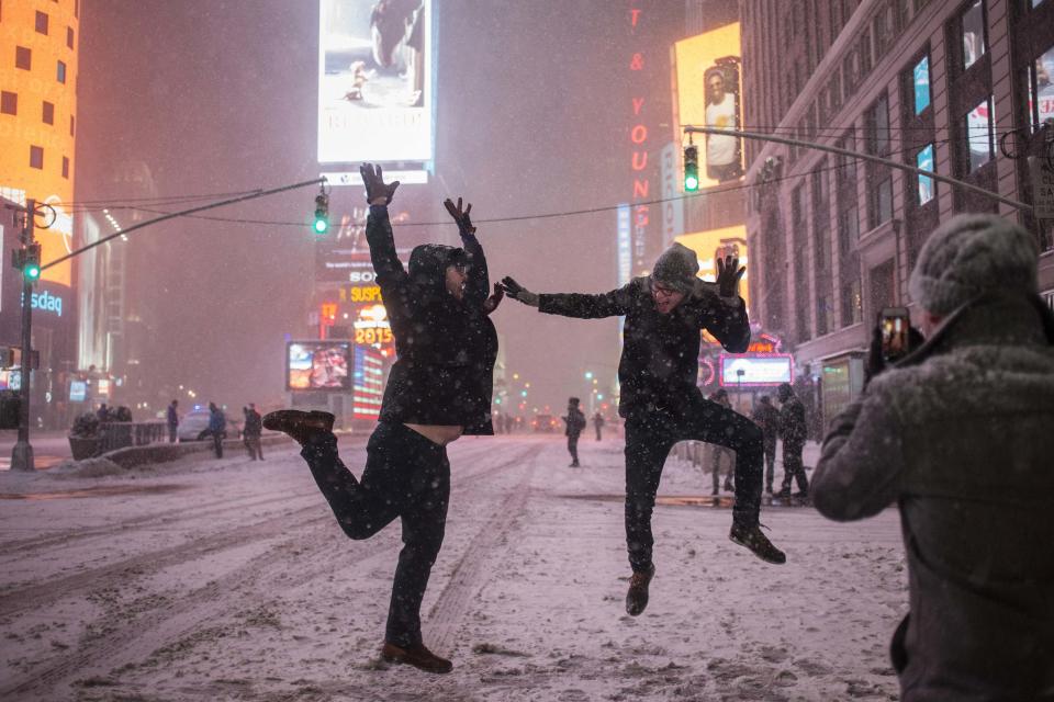 Men play in the snow along 7th Ave during a storm in Times Square, New York early morning January 27, 2015. A life-threatening blizzard barreled into the U.S. Northeast, affecting up to 20 percent of Americans by making workers and students housebound, halting thousands of flights and prompting New York to ban cars from roads and halt subway trains. REUTERS/Adrees Latif (UNITED STATES - Tags: DISASTER ENVIRONMENT SOCIETY)