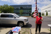 Defenders of the Unborn founder Mary Maschmeier, unfurls a U.S. flag outside Planned Parenthood Friday, June 24, 2022, in St. Louis. The Supreme Court has ended constitutional protections for abortion that had been in place nearly 50 years — a decision by its conservative majority to overturn the court's landmark abortion cases. Friday’s outcome overturning Roe v. Wade is expected to lead to abortion bans in roughly half the states. (AP Photo/Jeff Roberson)