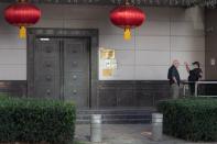 A man speaks to a security guard outside the China Consulate General in Houston, Texas