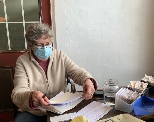 Patterson, president of the Sackville Food Bank, does a last bit of paperwork to prepare for the next day's pick-ups and deliveries. 