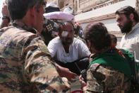 <p>Syria Democratic Forces (SDF) fighters chat with an injured civilian who was evacuated with others by the SDF from an Islamic State-controlled neighbourhood of Manbij, in Aleppo Governorate, Syria, Aug. 12, 2016. (REUTERS/Rodi Said) </p>