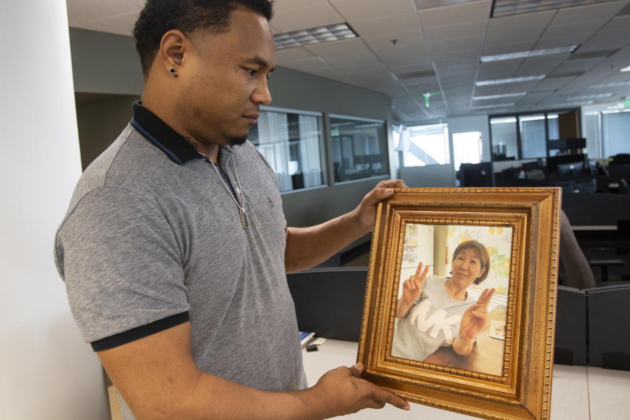Robert Peterson holds a photo of his late mother, Yong Ae Yue, one of the eight victims of the Atlanta-area spa shootings. (Ron Harris / AP)