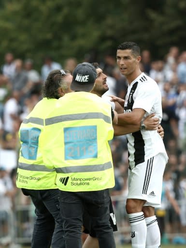 In demand: Juventus supporters invade the pitch to take a picture with Cristiano Ronaldo