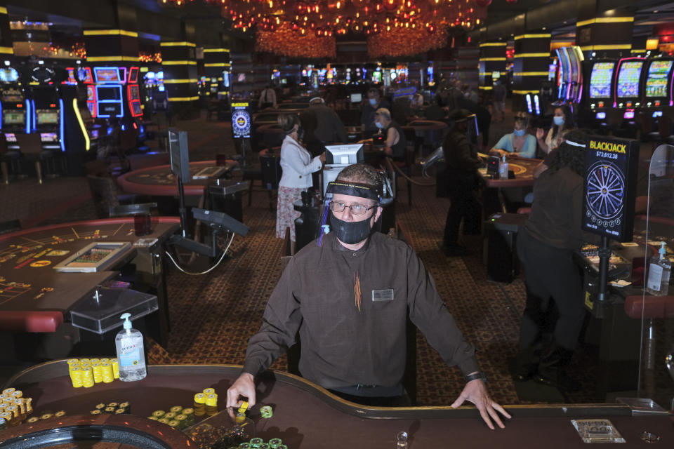 FILE - A dealer wears personal protective gear while working at the Golden Nugget Casino in Atlantic City, N.J., Thursday, July 2, 2020. Participants in a major casino conference Thursday, Sept. 22, 2022 in Atlantic City said the pandemic and its months-long closures taught them some useful lessons that could continue even after the pandemic is a distant memory, including not offering things like buffets that used to be taken for granted by casino players. (AP Photo/Seth Wenig, File)